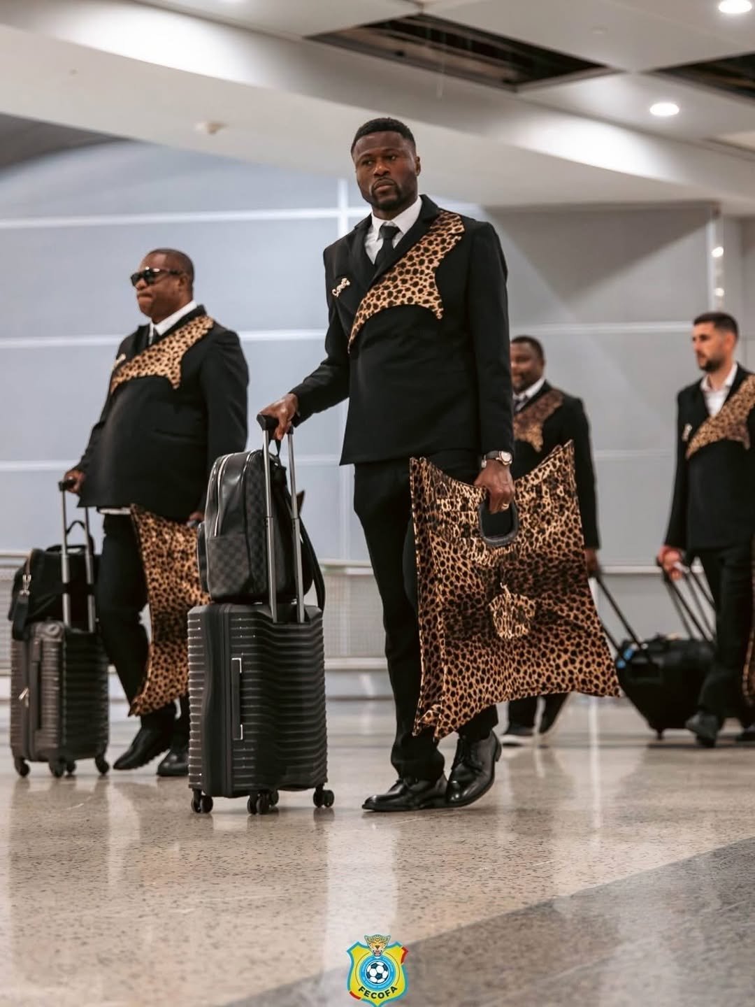 The Democratic Republic of Congo national team arriving in tailored leopard-print formalwear with luggage